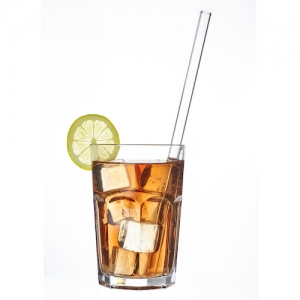 Long drink glass filled with a drink and ice cubes, a drinking straw Straw glass from TFA Dostmann is in the glass and a slice of lime graces the rim of the glass.